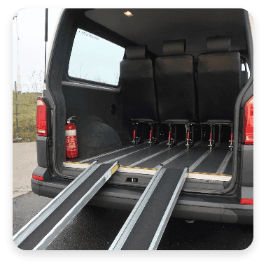 A wheelchair ramp leading into the back of a minibus.